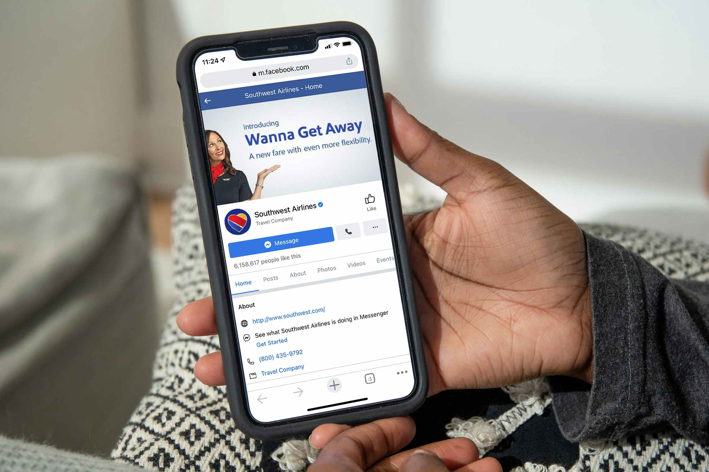 woman holding iPhone with screenshot of Southwest Airlines Facebook page