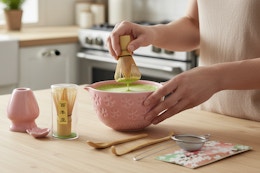 a woman using a matcha whisk set