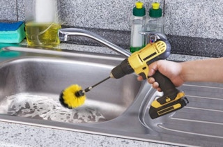 a drill with a brush cleaning a sink