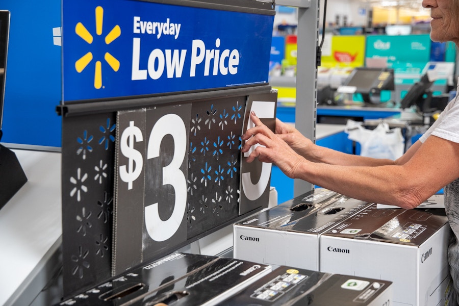 walmart employee changing price on store signage