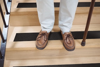 Grip tape on floor, a pair of feet with a cane