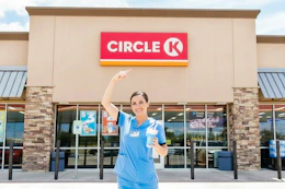 a nurse outside of Circle K with a drink