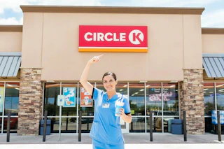 a nurse outside of Circle K with a drink