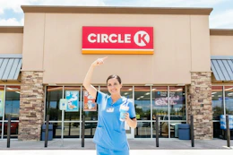 a nurse outside of Circle K with a drink