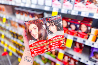 person holding 2 boxes of revlon hair color