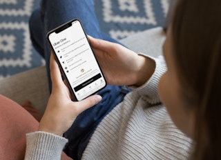 woman on a phone looking at the uber one pass page