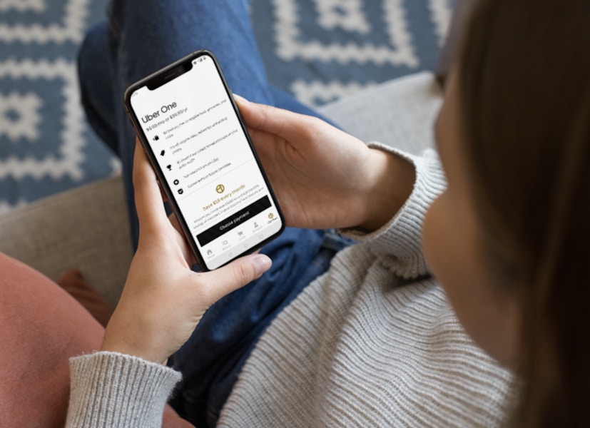 woman on a phone looking at the uber one pass page