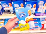 hand holding a six-pack of mr clean magic erasers at target