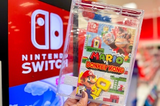 Hand holding Nintendo Switch Mario vs. Donkey Kong Video Game