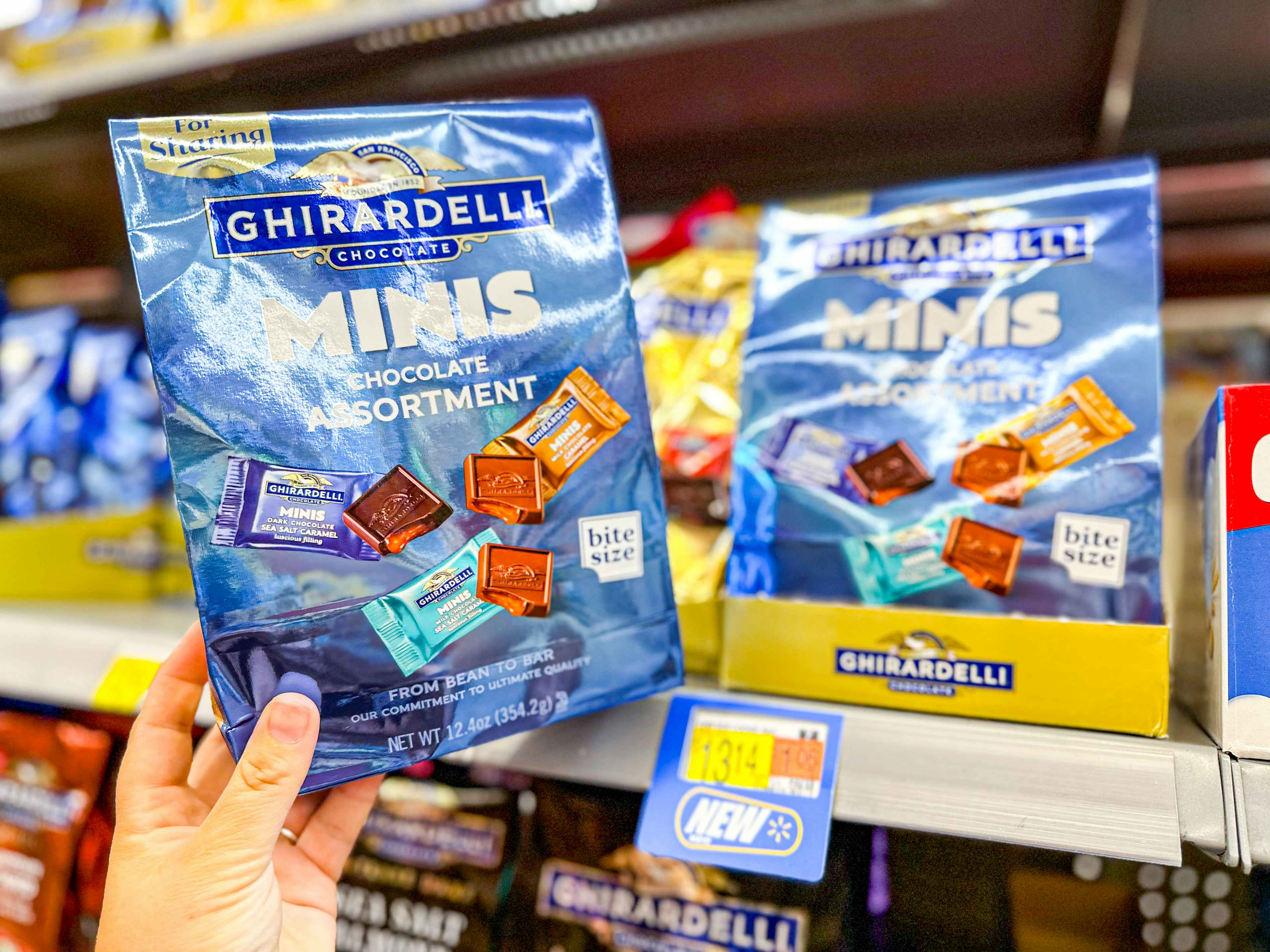 hand holding a bag of ghirardelli minis at walmart