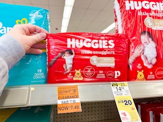 person grabbing huggies diapers from a shelf