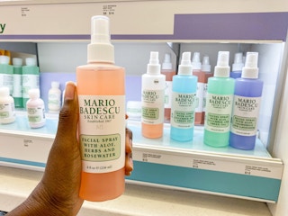 someone holding a pink bottle of mario badescu facia spray