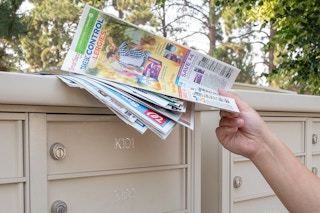 someone grabbing paper from top of mailbox