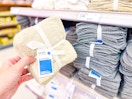 hand holding a room essentials washcloth set in front of a target shelf