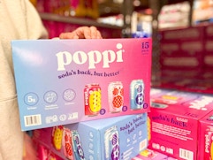 hand on case of poppi soda 