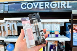 hand holding covergirl clean fresh lip balm and eyemakers pencils cvs