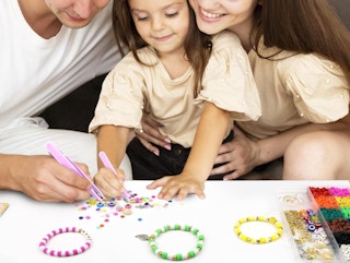 a family making bracelets at a table 