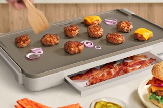 someone cooking on a bella electric griddle