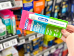 hand holding benadryl stick in walmart aisle