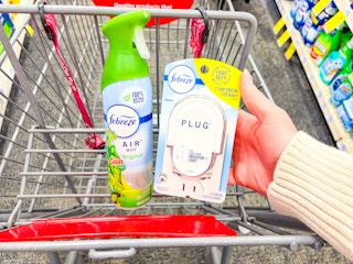 person placing a febreze plug warmer in a cart by air freshener