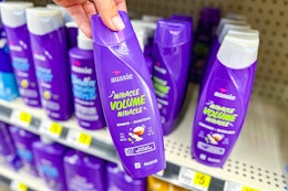 hand holding up a bottle of aussie shampoo at dollar general