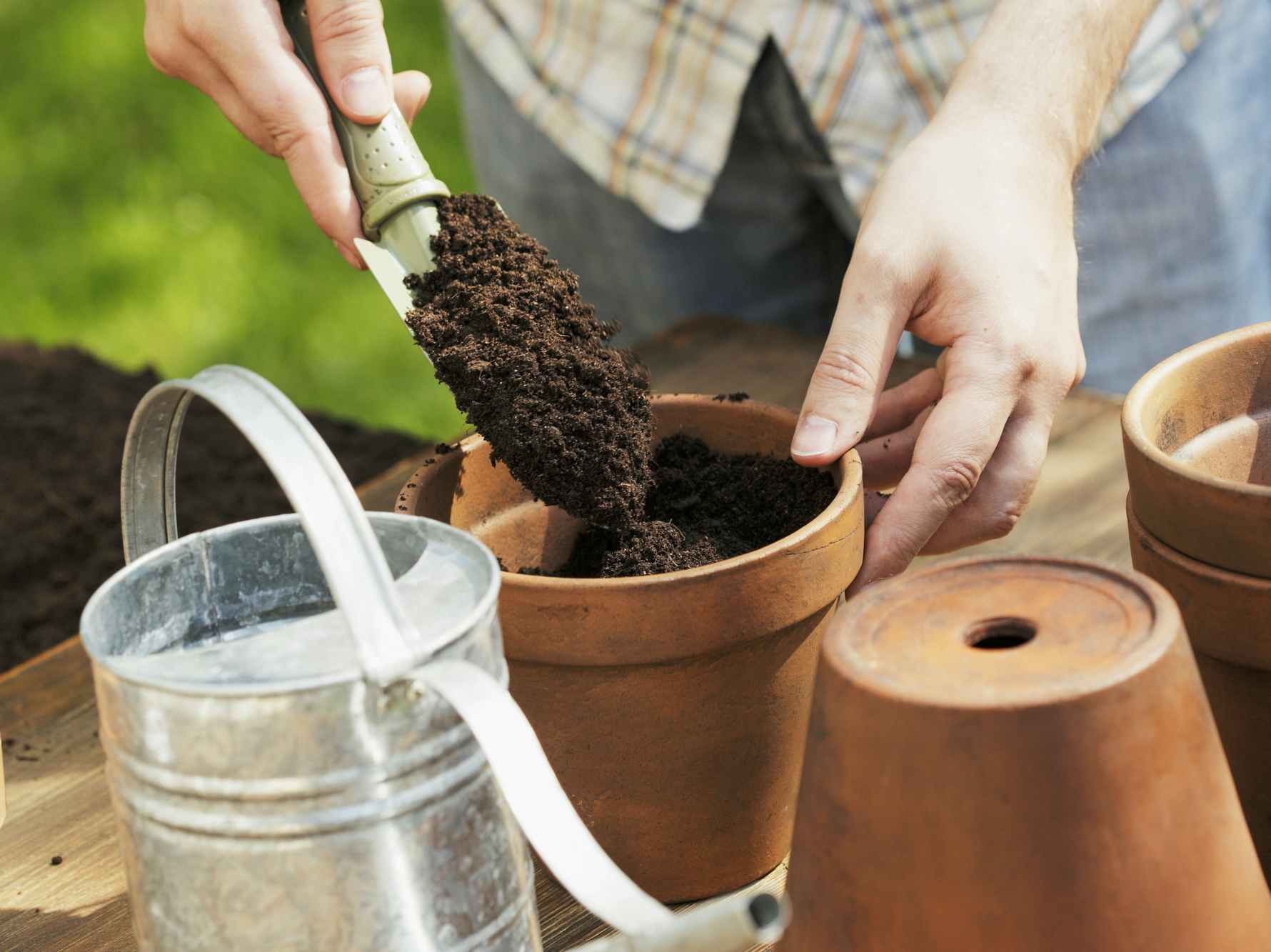 A person putting soil into a planter