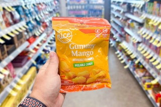 hand holding bag of peelable mango candy in walgreens store aisle