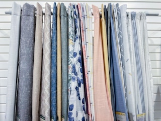An assortment of curtains hanging on a curtain rod
