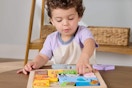 a boy using a fisher-price puzzle