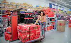 A woman pushing a cart loaded with craftsman tools at Lowe's