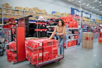 A woman pushing a cart loaded with craftsman tools at Lowe's