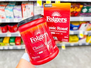 person holding folgers coffee