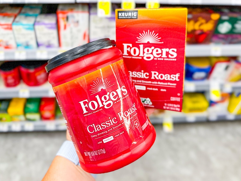 person holding folgers coffee
