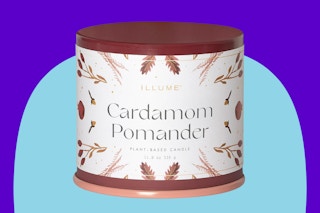 ILLUME Vanity Tin Candle, Cardamom Pomander on a blue background.