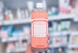 hand holding a bottle of Dr. Bronner's castile soap in aisle