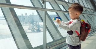 a child with an airplane toy at an airport