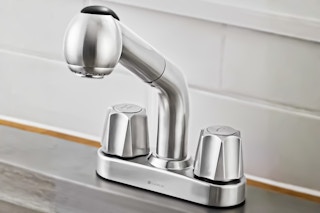Lifestyle image of the stainless steel Glacier Bay Pull-Out Laundry Faucet (close up shot)