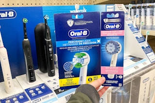 hand holding oral-b toothbrush and refills