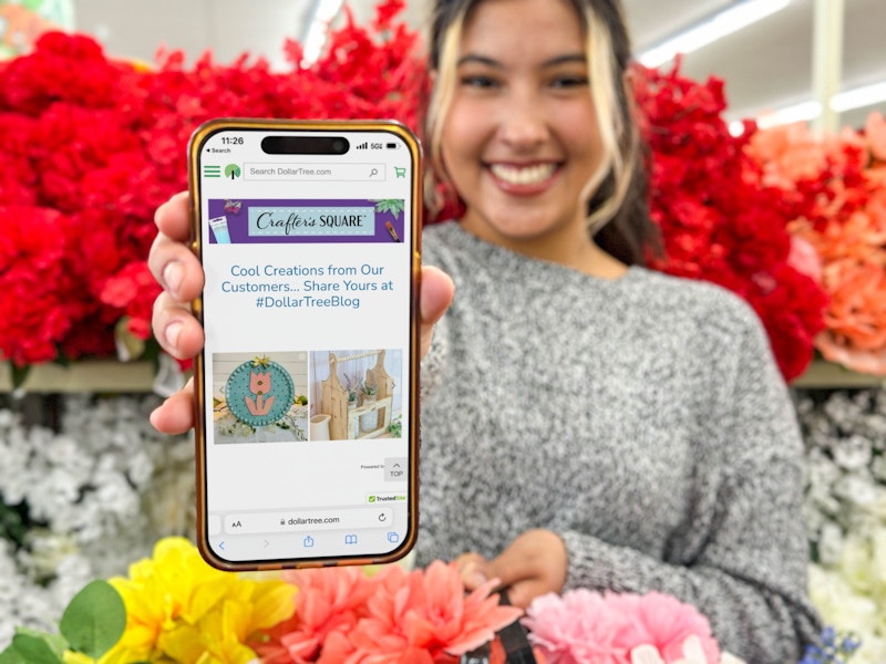 a woman holding out an iphone with the dollar tree blog on screen 