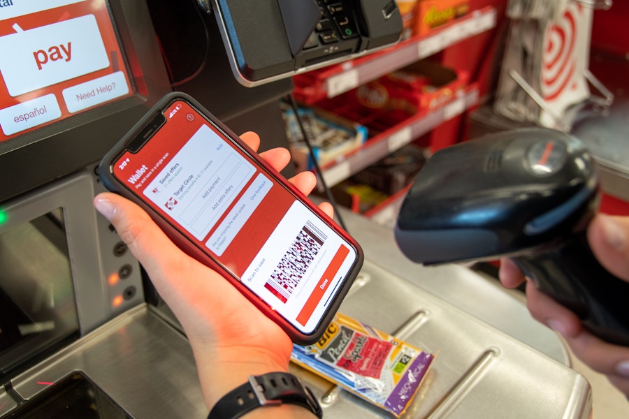 A woman scanning here Target app at a self-checkout register.