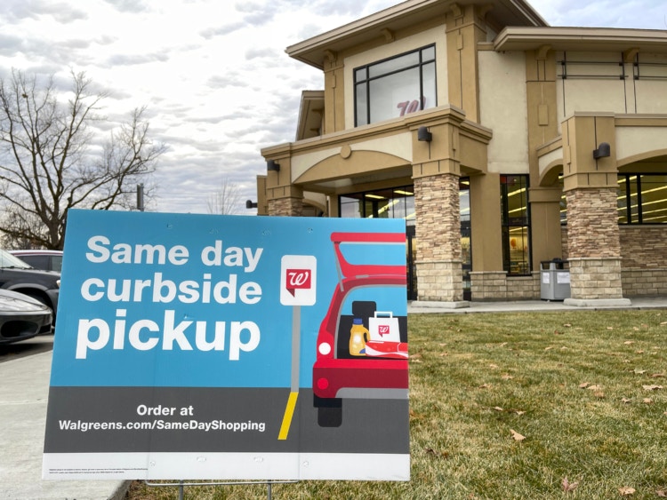 A curbside pickup sign in front of Walgreens.