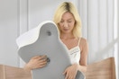 a woman holding a cervical neck pillow