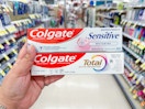 hand holding colgate toothpastes in walgreens