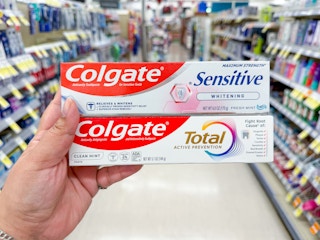 hand holding colgate toothpastes in walgreens