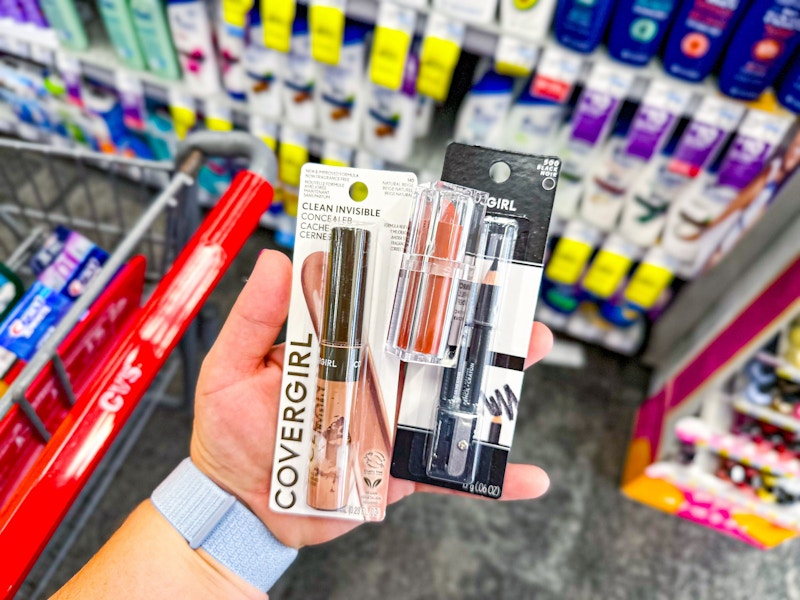 person holding covergirl cosmetics by a cvs cart