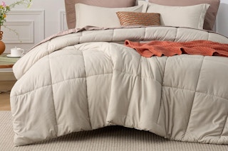 a beige queen comforter set on a bed
