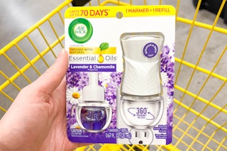 hand holding an air wick starter kit above a yellow shopping cart