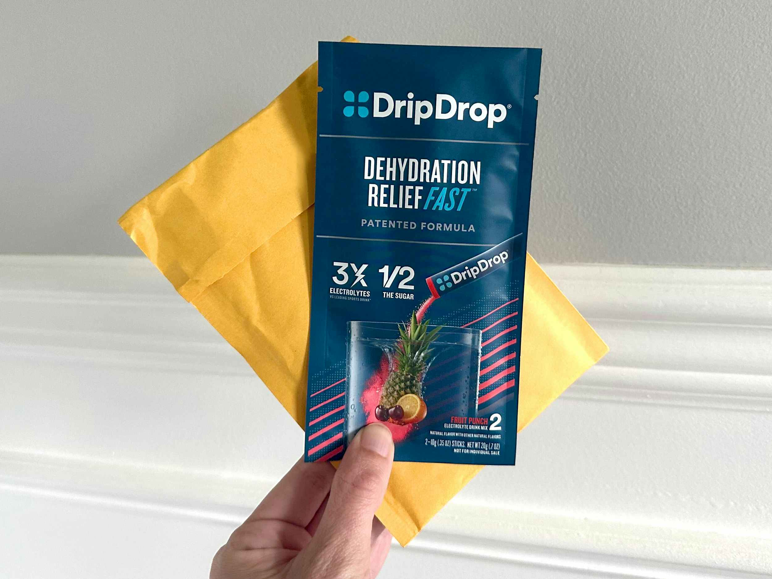 persons hand holding a dripdrop dehydration relief sample from amazon