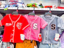 three toddler baseball jerseys hanging on walmart shelf