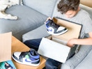 boy pulling nike sneaker out of box